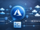 Create a wide-format feature image (21:9 aspect ratio) that visually represents Azure Virtual Network Manager. Use a modern, professional cloud architecture theme with Microsoft-style design cues. Include abstract network diagrams showing virtual networks, connectivity lines, hub-and-spoke and mesh topologies, and secure routing paths. Incorporate Azure colors (blue, cyan, white, dark background gradients) and subtle geometric patterns. Add visual elements suggesting centralized management, security shields, IP address blocks, and policy-based orchestration. Style should be clean, minimalistic, and suitable for a technical article header. (Designer prompt)